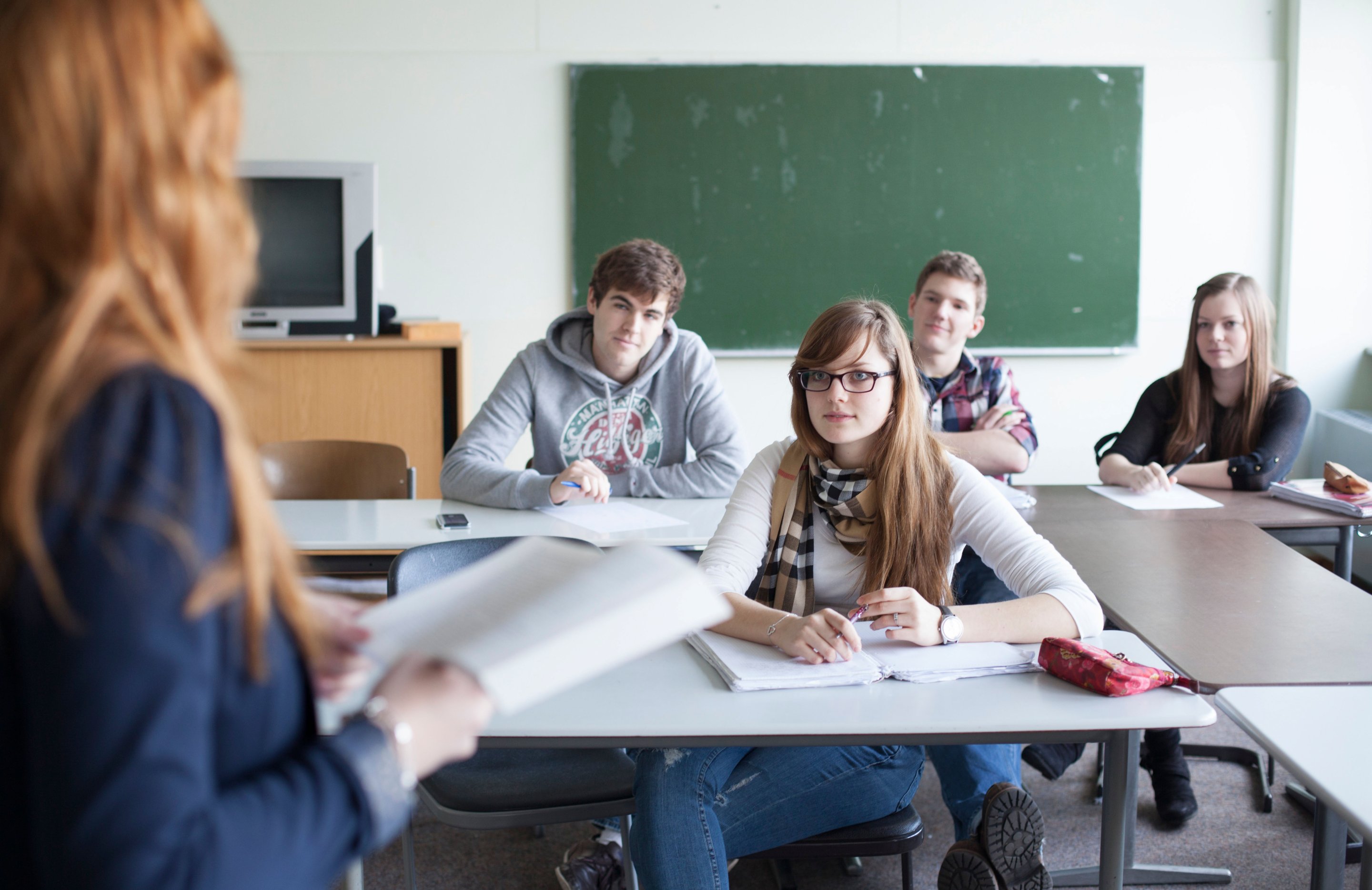 Junior high school students enjoying lesson at desks in classroom Stock  Photo - Alamy