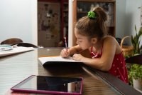 Young girl working on homework at her kitchen table
