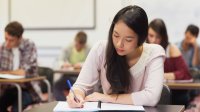 HIgh school student taking notes in class