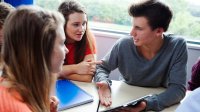 Group of high school students discussing project at school. 