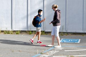 A student low-fives his mother goodbye before heading into school at San Jose Middle School.