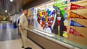 Principal Jeff Walters looks at a wall of college banners.