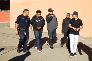 Franky Navarro, students, and Officer Singh walk together on campus at Castlemont High.
