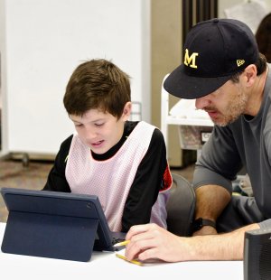 A boy and his father work on an assignment at Design39.