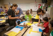 Parents and students looking at school work in a classroom