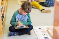Elementary student sitting on the floor and working independently
