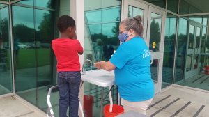 A staff member helps a student wash his hands at Educare Hawthorne.