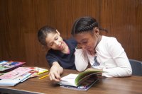 Two elementary school students reading a book together