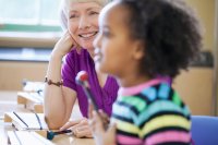 Music teacher smiling and playing xylophone with student