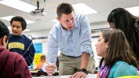 Elementary school teacher in classroom explaining math to students