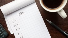 Photo of checklist, coffee, and pen on table