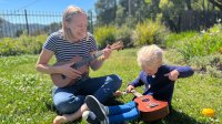 Lesley Chapman plays the ukulele with her toddler daughter outside