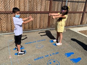 Elementary children standing on painted asphalt of school playground
