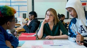 Teacher helping two students.