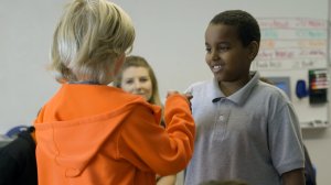 Two students fist bumping during circle practice at Valor Academy.