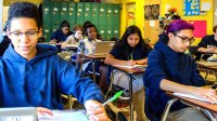 Middle school students write at their desks
