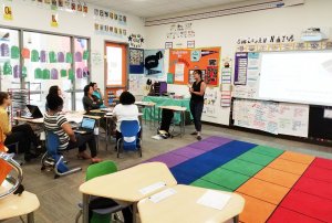 A representative from Landed talks to teachers at a school.