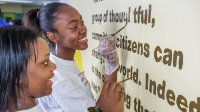 Teens work on a mural for a community service project