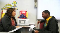 High school student meets with teacher for help with Spanish language class