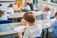 Elementary school student writing at his desk