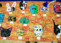 A table covered in student-made papier-mâché masks