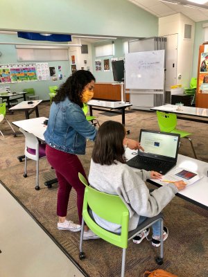 Candice Aguirre, a science teacher at Marin’s Community School, works with a student. Classrooms were restructured to create more space between desks.