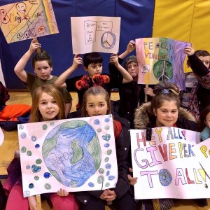 New Jersey students hold up signs during the peace sign project. 