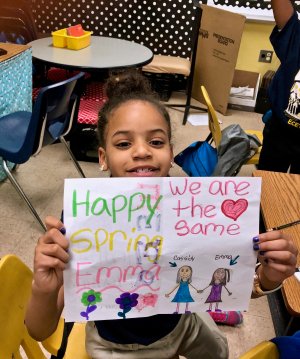 A student holds up a letter she received from her pen pal in New Jersey.