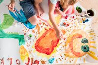 Kids painting together on a large piece of paper