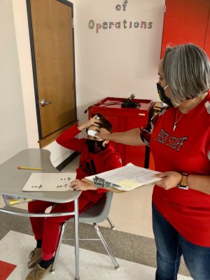 A staff member checks a student's temperature in Premont.