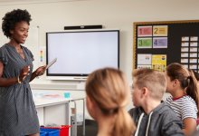 Middle school teacher speaking to students in classroom