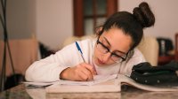 Middle school girl at home works on homework.