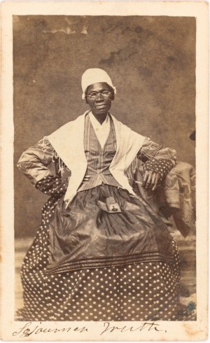Photo portrait of Sojourner Truth seated with photograph of her grandson, James Caldwell of Co. H, 54th Massachusetts Infantry Regiment, on her lap