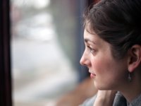 A close up of a young teacher's face as she's looking out the window from inside a classroom