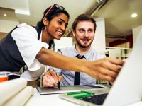 Two happy adults working together at a laptop