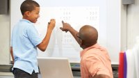 A student consults with his teacher about a math problem.