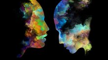 Two colorful heads made of paint against a black backdrop are facing each other. 