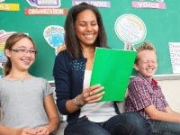 Teacher reading with a girl and boy next to her