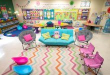 A colorful classroom with couches, collapsible desks, and scoop chairs