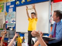 Boy standing in front of the class holding a big key