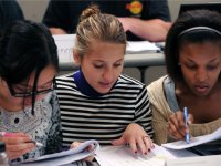 photo of three young women working on a project together