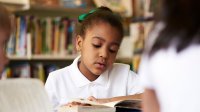 photograph of a young girl reading a book