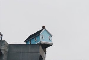 House balanced at edge of other building