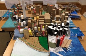 A scale model of lower Manhattan made out of cardboard and colored paper.