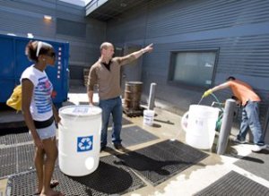 Teacher and student outside with water recycling bins