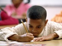 Boy in deep concentration writing with pencil