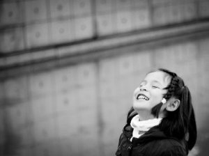 Black and white photo of a child smiling brightly