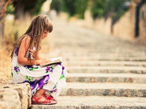 Young girl reading on steps