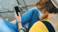 Photo of young person looking down at smartphone