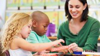 A teacher uses counting blocks with two young students.